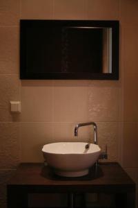 a sink in a bathroom with a tv on the wall at Aisahome in Pärnu