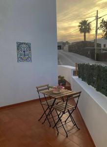 uma mesa e cadeiras numa varanda com um quadro em La Casa del Sole em Pantelleria
