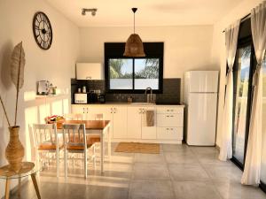 uma cozinha com uma mesa e um frigorífico branco em שפיגל קו ראשון לנחל-Hagoshrim,הגושרים em Hagoshrim