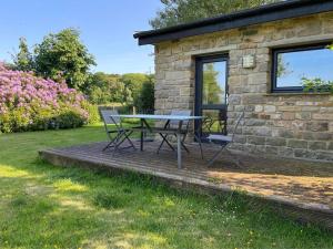 a table and chairs sitting outside of a stone house at Locka Old Hall Cottage in Arkholme