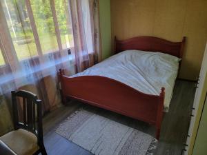 a bed in a bedroom next to a window at Sunny apartment next to a beautiful lake in the forest in Imatra