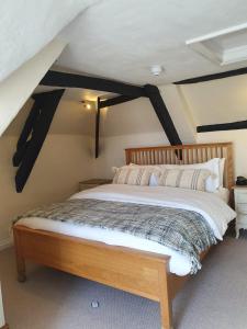 a bedroom with a wooden bed in a attic at The Old Thatch Inn in Cheriton Bishop