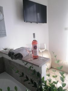 una bottiglia di vino seduta su un tavolo con due bicchieri da vino di Casa rosa Abruzzo 3 a Musellaro