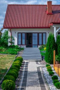 una casa con techo rojo y pasarela en Lakeside Home, en Ryn