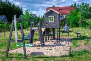 un parque infantil con tobogán y estructura de juegos en Lakeside Home, en Ryn