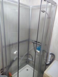 a shower with a glass door in a bathroom at The Private Quarters in Vårsta