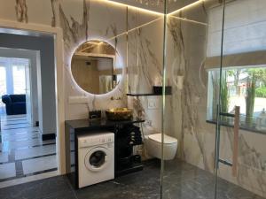 a bathroom with a washing machine and a mirror at Ośrodek Wczasowy REWA in Rewa +91 photos