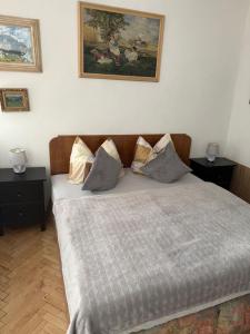 a bed in a room with two night stands and a painting at Apartments & Restaurant Tkalcovsky dvur in Prague