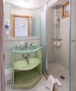 y baño con lavabo verde y ducha. en Maristella, en Positano