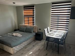 a bedroom with a bed and a table and chairs at ML Place 4 in Liepāja