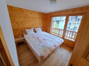 ein Schlafzimmer mit einem Bett in einem Holzzimmer in der Unterkunft Appartement de charme - Idéal pour un couple in Nendaz