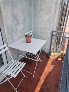 d'une table et de chaises blanches sur un balcon. dans l'établissement Malpensata, à Bergame