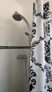 a shower with a black and white shower curtain at The Brill'S - הברילים in Beʼer Ora