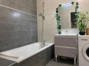ein Badezimmer mit einer Badewanne und einem Waschbecken in der Unterkunft Lovely flat border to Monaco- private parking - sea view and terrace in Beausoleil