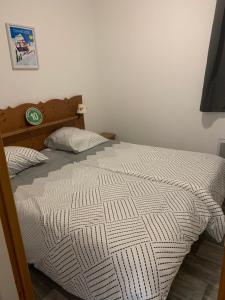 a bed with a white comforter in a bedroom at L'écrin du Bachat Chamrousse in Chamrousse