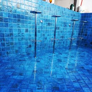 ein blau gefliestes Badezimmer mit vier Toiletten in einem Raum in der Unterkunft Linda casa de Veraneio in Guarujá + 8 Fotos