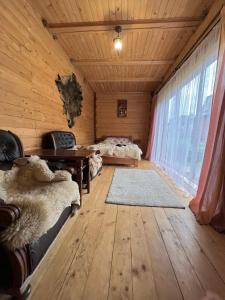 um quarto com paredes de madeira e um quarto com 2 camas em Лісова пісня em Verkhovyna