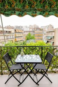 einen Tisch und zwei Stühle auf einem Balkon in der Unterkunft Cosy apartment 700m from Acropolis in Athen
