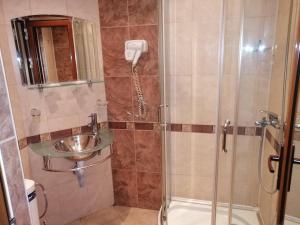 La salle de bains est pourvue d'une douche et d'un lavabo. dans l'établissement ХОТЕЛ ОМЕГА, à Stara Zagora