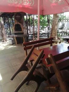 a table and chairs under a red umbrella at ХОТЕЛ ОМЕГА in Stara Zagora