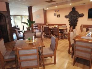 Un restaurante con mesas y sillas de madera en una sala. en ХОТЕЛ ОМЕГА, en Stara Zagora