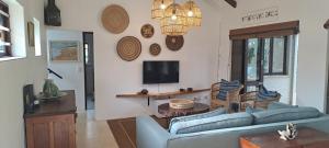 a living room with a blue couch and a tv at Seaside Serenity - Your ultimate beachfront escape in Sheffield Beach