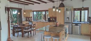 a kitchen with a table and a refrigerator and chairs at Seaside Serenity - Your ultimate beachfront escape in Sheffield Beach