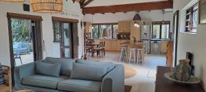 a living room with a couch and a kitchen at Seaside Serenity - Your ultimate beachfront escape in Sheffield Beach