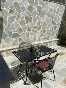 een zwarte tafel en 2 stoelen op een patio bij Olympia's Guest House in Volos