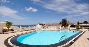 a large swimming pool with the ocean in the background at Arthouse Sea View - Acquamarina e Zaffiro in Puerto del Carmen