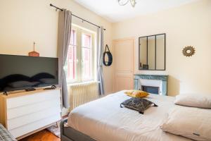 Schlafzimmer mit einem Bett, einer Kommode und einem Spiegel in der Unterkunft La Villa Bligny in Étretat