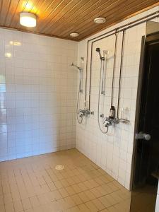 a bathroom with a shower and a tiled wall at Norppa Resort in Savonlinna