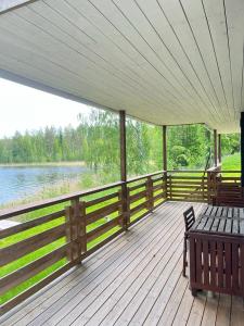 een houten terras met een bank en uitzicht op een meer bij Norppa Resort in Savonlinna