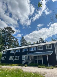 a large blue building with white windows and trees at Norppa Resort in Savonlinna