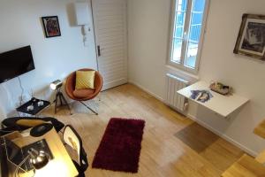 un salon avec une chaise, un bureau et une fenêtre dans l'établissement Le Duplex des Halles, à Pau