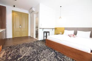 a bedroom with a large bed and a kitchen at Sarajevo History Apartments in Sarajevo