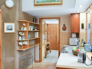 a kitchen with wooden shelves and a sink at Sithean in Taynuilt