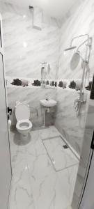 a white bathroom with a toilet and a sink at Beach Appartment close to Marina 105 sqm in Agadir +29 photos