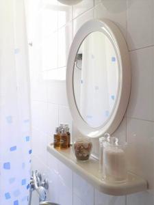 a white bathroom with a mirror and a sink at Daphnes Apartments in Ratzaklíon +23 photos