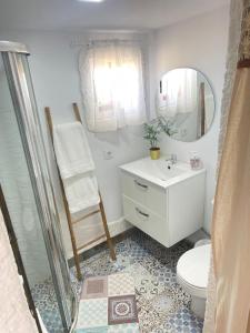 a bathroom with a toilet and a sink and a mirror at Finca el atardecer- Apartamento El Peral in Los Santos de Maimona