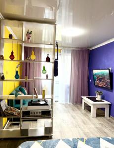 ein Wohnzimmer mit einer blauen und gelben Wand in der Unterkunft Яркая квартира в стиле Поп Арт в центре города Караганда in Qaraghandy