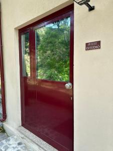 una puerta roja con un letrero que lee la entrada a un edificio en Quinta do Rio Gerês, en Bouro