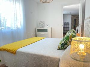 a bedroom with a bed with a yellow blanket on it at Finca el atardecer- Apartamento El Peral in Los Santos de Maimona