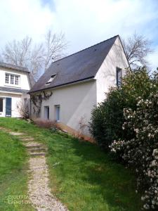 a white house with a black roof at La fantasia gîte in Saint-Sylvain-dʼAnjou