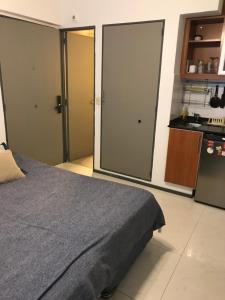 a bedroom with a bed and a small kitchen at Monoambiente cómodo in Buenos Aires