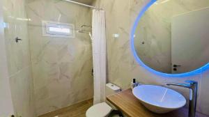 ein Badezimmer mit einem weißen Waschbecken und einem Spiegel in der Unterkunft Boho Vibes Beachfront Detached House in Análipsis