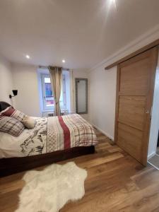 a bedroom with a bed and a wooden door at Appartement Aroma Snow in Briançon