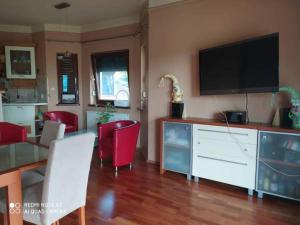 a living room with a television and a table and chairs at Apartament Vip Marysieńka in Kąty Rybackie