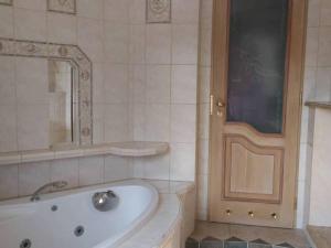 La salle de bains est pourvue d'une baignoire, d'un lavabo et d'un miroir. dans l'établissement Apartament Vip Marysieńka, à Kąty Rybackie