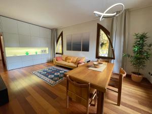 パドヴァにあるLe Palme - Appartamento elegante e moderno con garage privatoのリビングルーム(テーブル、ソファ付)
